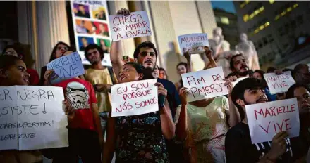  ?? Lucas Landau/Folhapress ?? Manifestan­tes exibem cartazes em protesto de repúdio à morte de Marielle Franco em frente à Alerj, no Rio, nesta sexta