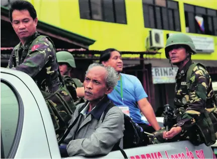  ?? Romeo Ranoco / Reuters ?? Locals board a government vehicle after being rescued by the military in Marawi City.