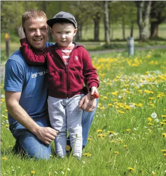  ??  ?? Paudie Guerin and his boy, Darragh, from Listowel, enjoying the sun in a bed of Dandelions in the Listowel Town Park – as the temperatur­e reached 19 degrees centigrade in the town .