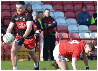  ??  ?? Derry’s Shea Downey see off a challenge from Louth’s James Craven.