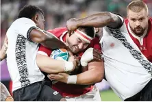 ?? AFP ?? Wales' prop Wyn Jones, center, is tackled during the Wales-Fiji match.