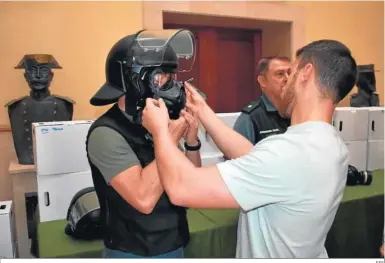  ?? EFE ?? Un agente de la Guardia Civil de Melilla se prueba un casco y una máscara antigás enviados por Interior.