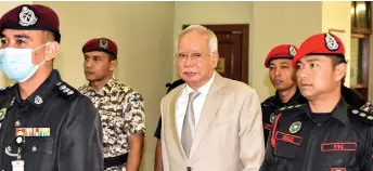  ?? — Bernama photo ?? Najib is escorted at the court by Prisons officers.