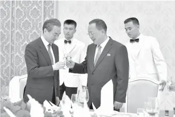  ?? AGENCE FRANCE PRESSE ?? Chinese Foreign Minister Wang Yi (left) and North Korea’s Foreign Minister Ri Yong Ho raise their glasses in a toast during a meeting in Pyongyang.