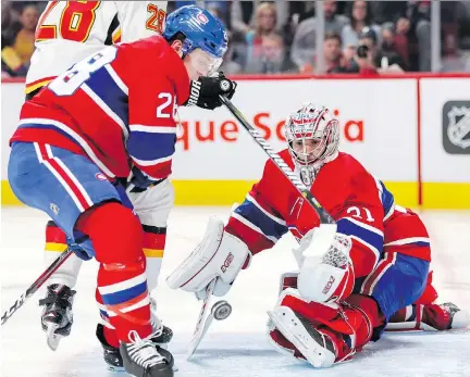  ?? JOHN MAHONEY ?? Canadiens goaltender Carey Price makes a save as defenceman Mike Reilly looks to clear the rebound during second period of Tuesday’s game against the Calgary Flames at the Bell Centre. The Canadiens avoided another late-game meltdown for a 3-2 victory.