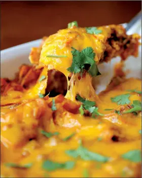  ?? Food styling/KELLY BRANT Arkansas Democrat-Gazette/STEPHEN B. THORNTON ?? Easy Enchiladas, shown here topped with a sprinkling of cilantro, can be doubled or tripled as needed.