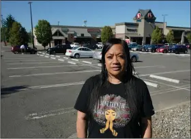  ?? ?? Marty Jackson, director of the SE Network, a community group whose work includes increasing the safety of community gathering places, stands July 12 in the parking lot of a Safeway store in Seattle’s Rainier Beach neighborho­od, where her group holds weekly gatherings to provide food, referrals to services and “healing spaces” for people affected by violence.
