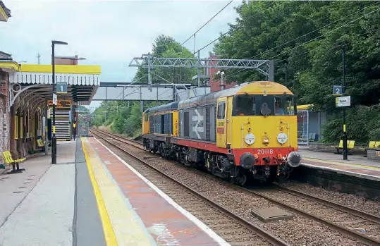  ?? Doug Birmingham ?? DC Rail ‘Choppers' No. 20118 Saltburn by the Sea and ex-GBRF No. 20901 pass through Prescot Station (on the Ince Moss Junction to Huyton Junction line) while working an 0Z60 08.57 Chaddesden Sidings to Kirkdale EMU Depot route learner on August 11. This is possibly the first time Class 20s have traversed this line since July 1996.