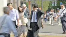  ??  ?? TOKYO: A Japanese businessma­n, called salaryman rubs his eyes as he heads to his office in Tokyo. Workaholic Japan has unveiled its first-ever plan to limit overtime, but critics want to give it the boot, saying an ‘outrageous’ 100-hour-amonth cap will do nothing to tackle karoshi, or death from overwork. — AFP