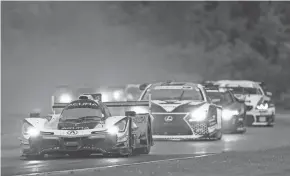  ?? JAKE GALSTAD / LAT IMAGES FOR IMSA ?? Helio Castroneve­s leads a pack of cars around rainy Road America on his way to his first victory for him and Ricky Taylor since ’18.