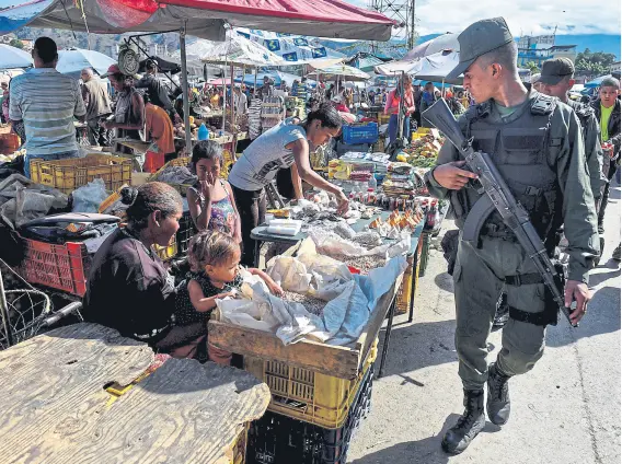  ?? FEDERICO PARRA/AFP ?? Un miembro de la Guardia nacional patrulla un mercado en el barrio popular de coche, en caracas