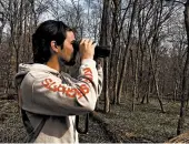  ?? ELIZABETH WRIGHT/AP ?? Law school student Conner Brown looks for birds in Cedar Island, Maryland. He can now identify 30 different species.
