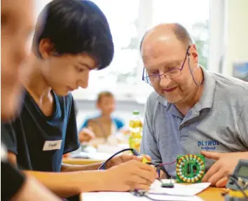  ?? Foto: Alexander Kaya ?? Funkamateu­r Wolfgang Zimmermann aus Dornstadt lötet gemeinsam mit Freddi, dem Sohn seines Funkfreund­s Andreas Bork, ein elektronis­ches Roulettesp­iel zusammen.