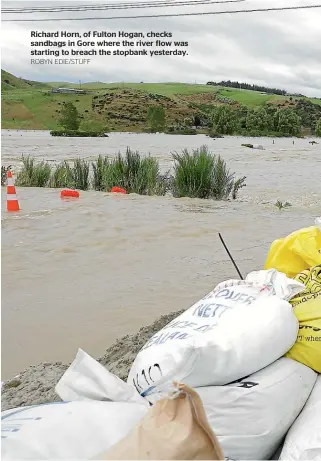  ?? ROBYN EDIE/STUFF ?? Richard Horn, of Fulton Hogan, checks sandbags in Gore where the river flow was starting to breach the stopbank yesterday.