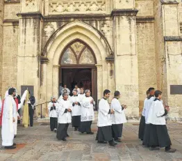  ?? Billy Calzada / Staff file photo ?? Catholic clergy and other faithful exit after Mass at San Fernando Cathedral to participat­e in a procession to celebrate the Feast of Corpus Christi in June.