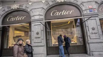  ?? | MARTIN DIVISEK ?? PEDESTRIAN­S look at the window display of a Cartier luxury store, a unit of Richemont, in Prague, Czech Republic. Richemont sales are showing slow growth. Bloomberg