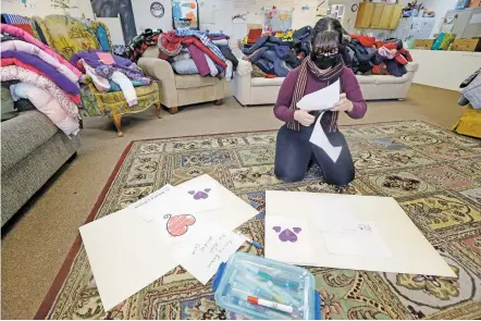  ?? PHOTOS BY LUIS SÁNCHEZ SATURNO/THE NEW MEXICAN ?? Sayra Lozano creates posters Thursday in preparatio­n for the Gerard’s House holiday drive. Three years ago, the Nuestra Jornada program for immigrant families at Gerard’s House gave Lozano solace. Later, it gave her a job.