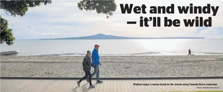  ?? Photo / Hayden Woodward ?? Walkers enjoy a sunny break in the clouds along Tamaki Drive yesterday.