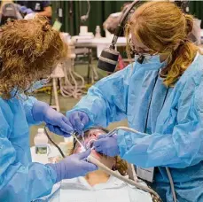  ?? Times Union archive ?? Dental hygienist Lori St. John, left and Dr. Deborah Harmance of Gloversvil­le, right, work on a patient at a New York State Mission of Mercy dental tour stop in 2014 at Hudson Valley Community College.