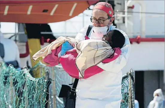  ?? ANTONIO PARRINELLO / REUTERS ?? Un metge atén un nen durant un desembarca­ment de immigrants d’un vaixell de Metges sense Fronteres al port de Pozzallo, a Sicília