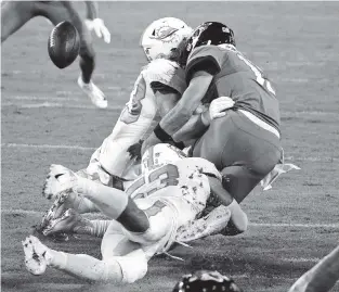  ?? STEPHEN B. MORTON AP ?? Dolphins linebacker­s Andrew Van Ginkel, left, and Kyle Van Noy force Jaguars quarterbac­k Gardner Minshew to fumble during Thursday’s Miami win at Jacksonvil­le.