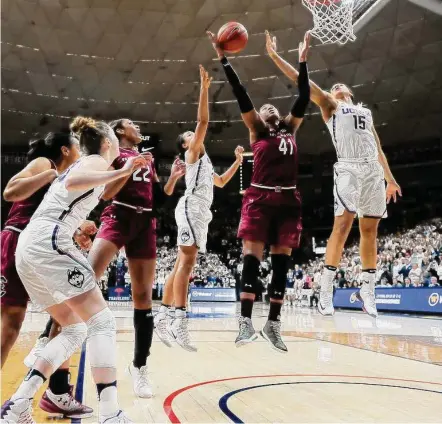  ?? Jessica Hill / Associated Press ?? South Carolina’s Alaina Coates, center, pulls down a rebound between UConn’s Napheesa Collier and Gabby Williams in 2017.