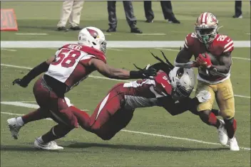  ?? ASSOCIATED PRESS ?? SAN FRANCISCO 49ERS RUNNING BACK Jerick McKinnon (28) runs against Arizona Cardinals middle linebacker Jordan Hicks (58) and outside linebacker De’Vondre Campbell during the first half of a game in Santa Clara, Calif., on Sunday.