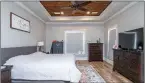  ??  ?? A tray ceiling with a tongue-and-groove inlay adds appeal to the master bedroom.