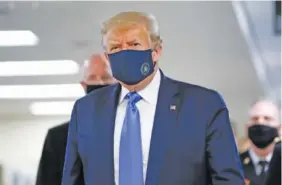  ?? AP PHOTO/PATRICK SEMANSKY ?? President Donald Trump wears a mask as he walks down the hallway during his visit Saturday to Walter Reed National Military Medical Center in Bethesda, Md.