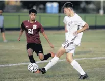  ?? MICHAEL GARD/DAILY SOUTHTOWN ?? Argo’s Gerard Kleczewski, right, moves the ball forward as T.F. United’s Adan Cabrera approaches during Monday’s game at T.F. North in Calumet City.