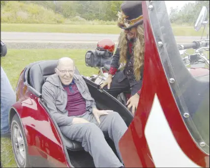  ??  ?? Kent Sill is smiles after being placed in a motorcycle sidecar for a ride, at the Heart of the Valley long-term care facility in Middleton Wednesday. At right is motorcycle celebrity and Wharf Rat Rally ambassador Kevin Bean’re, who drove the bike.