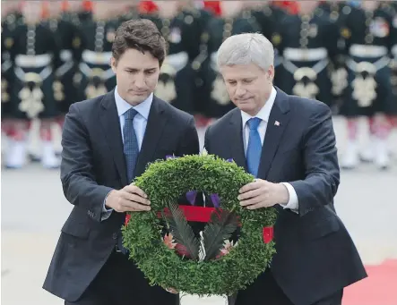  ?? SEAN KILPATRICK/ THE CANADIAN PRESS ?? Prime minister- designate Justin Trudeau and outgoing Prime Minister Stephen Harper place a wreath Thursday at the National War Memorial during a ceremony marking the one- year anniversar­y of the attack on Parliament Hill.