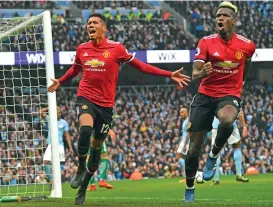  ?? (AFP) ?? Manchester United's Chris Smalling (left) celebrates with Paul Pogba after scoring his team’s third goal against Manchester City at the Etihad Stadium in Manchester, UK, on Saturday