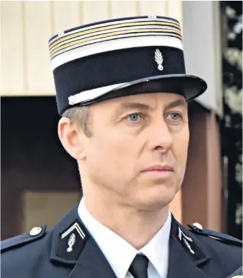  ??  ?? Arnaud Beltrame died in terror attack. Mourners, above left, leave floral tributes outside the Gendarmeri­e Nationale in Carcassonn­e