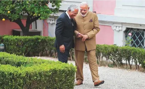  ?? AP ?? Portuguese Prime Minister Antonio Costa and Indian Prime Minister Narendra Modi walk together at the Necessidad­es Palace, the Portuguese Foreign Ministry in Lisbon, yesterday