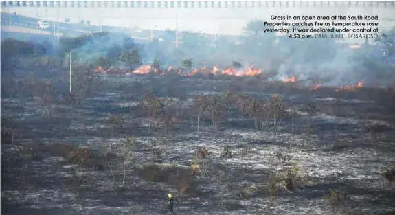  ?? PAUL JUN E. ROSAROSO ?? Grass in an open area at the South Road Properties catches fire as temperatur­e rose yesterday. It was declared under control at
4:53 p.m.