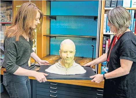 ?? Pictures: Steve Brown. ?? Rachel McGarvey and Sara Kelly, local studies officer, place “Daft Archie” in the display cabinet; below: Rachel with the facial reconstruc­tion.