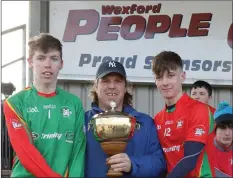  ??  ?? Joint captains Anto Larkin and Lee Jordan accepting the Jim Byrne Cup from James Mullally.