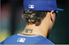  ?? THE ASSOCIATED PRESS FILE ?? Javier Baez sports an MLB logo tattoo and logos on his hat and jersey as he waits to take batting practice before Game 2the 2017NLDS against the Nationals.