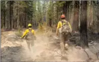  ??  ?? Firefighte­rs Garret Suza (right) and Cameron Taylor, with the Chiloquin Forest Service, search for hot spots on the North East side of the Bootleg Fire on Wednesday near Sprague River, Ore. (AP Photo/Nathan Howard)