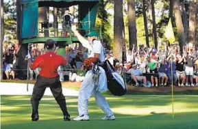  ?? ELISE AMENDOLA AP ?? Tiger Woods and caddie Steve Williams react after his chip-in birdie, where the ball hesitated on the lip with the Nike swoosh showing, on the 16th hole during the 2005 Masters.