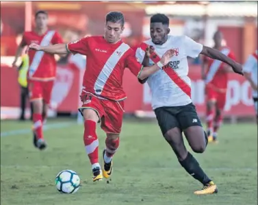  ??  ?? LUCHA. El rayista Embarba y el sevillista Yan Eteki pugnan por un balón durante el partido.