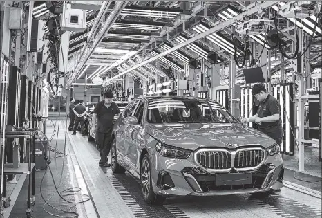  ?? PROVIDED TO CHINA DAILY ?? Employees work on a BMW assembly line in Shenyang, Liaoning province,