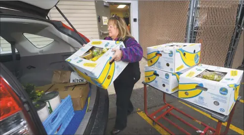  ?? Erik Trautmann / Hearst Connecticu­t Media file photo ?? Food Rescue U.S. volunteer Lyn DeTroy picks up food from Trader Joe's in Westport last November, for delivery to the Family and Children's Agency in Norwalk. Food Rescue U.S., transfers usable food from grocers, restaurant­s, catering events, to food insecure families throughout the U.S.