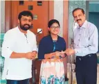  ?? Courtesy: Satish family ?? Dr Azad Moopen (right) presenting the cheque for Rs500,000 to Suchetha Satish and Ajay Gopal.