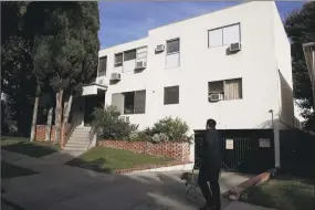  ?? Jae C. Hong / Associated Press ?? A man walks his dog past an apartment building where a man identified Thursday as 55-year-old Timothy Dean, of West Hollywood, Calif., died Monday in the apartment of Democratic Party donor Ed Buck, in West Hollywood.