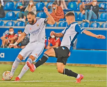  ?? — AFP ?? Real Madrid’s Karim Benzema (left) vies for the ball with Pere Pons of Alaves during their Spanish League match at the Mendizorro­za stadium in Vitoria on Saturday.