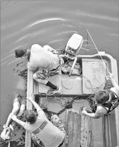  ?? — Photos by Lynzy Billing ?? The coast guard arrives to bring a body ashore in the Estero de Vitas under a bridge in Tondo, Manila, last month.