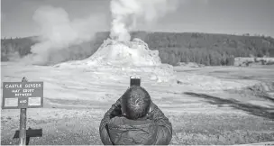  ?? JOSH HANER/NEW YORK TIMES ?? A young visitor photograph­s Castle Geyser in Yellowston­e National Park on Oct. 15. The Yellowston­e of charismati­c megafauna and of stunning geysers that four million visitors a year travel to see is changing before the eyes of those who know it best.