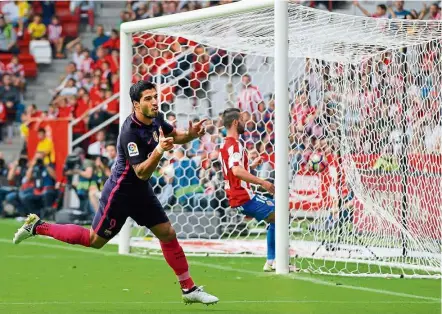  ?? — EPA ?? Spectacula­r strike: Barcelona forward Luis Suarez celebrates after scoring against Sporting Gijon during the Spanish League match at the El Molinon Stadium yesterday. Barca won 5-0.